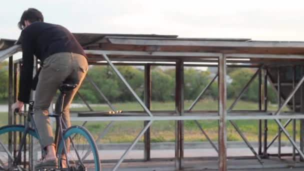 Stilig kille ridning en cykel Fixie och gör Tricks. — Stockvideo