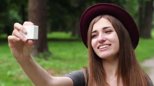 Schönes Touristenmädchen macht Selfie-Kamera zum Einsatz. die Frau ist sehr schön. Sie fotografiert sich selbst im Park. Blogger. — Stockvideo