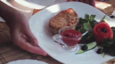 Garson bir kazıkla bir tabak bir masanın üzerine koyar..