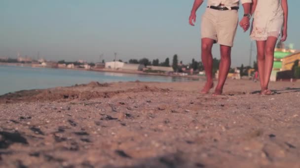 Pár a strandon. A srác és a lány mezítláb hajnalban. — Stock videók
