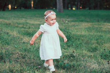 Küçük güzel kız parkta yürüyor. Çok güzel.