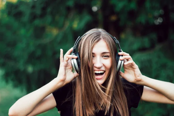 Schönes Mädchen, das Musik über Kopfhörer hört . Stockfoto