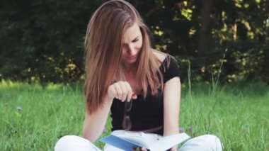 mutlu güzel bir kız parkta bir kitap okuma .