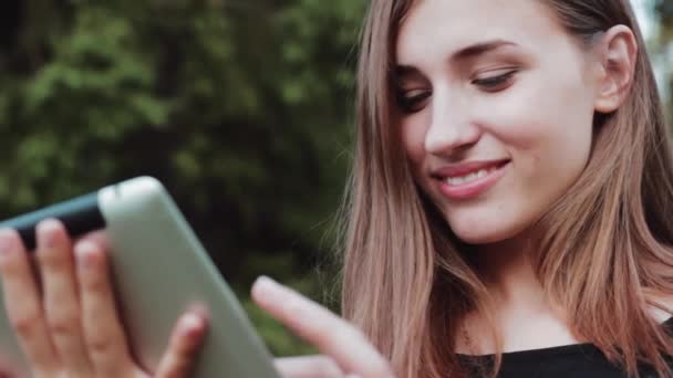 O tipo de menina alegre e bonita no tablet . — Vídeo de Stock