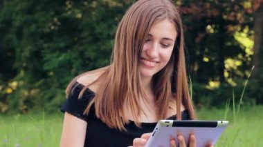 Neşeli kız tablet sosyal ağlar üzerinde çalışıyor.