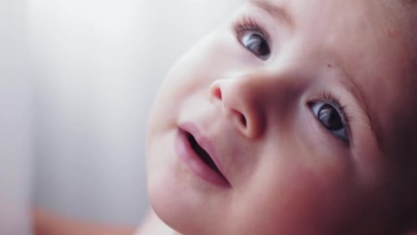 Looking Beautiful Child. Beautiful girl at the window . — Stock Video