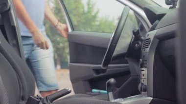 Sürücü arabada oturup, kapı kapanır ve kemer takılır. -Arabayı çalıştır. Araba metalik renkler.