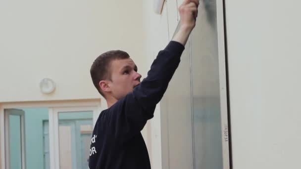 Ein junger Lehrer unterrichtet die Studenten an der Universität. Ein Mann schreibt an die Tafel. — Stockvideo