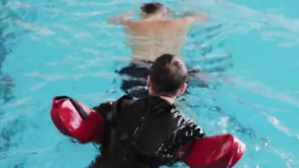 Man swimming in the pool to save a drowning man. Lifeguard Saves Drowning. Training of Rescuers. — Stock Video