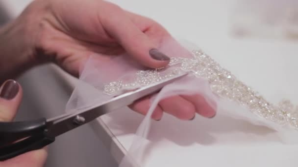 Шитье свадебных платьев. Ножницы для швеи разрезают пояс украшениями для свадебных платьев . — стоковое видео