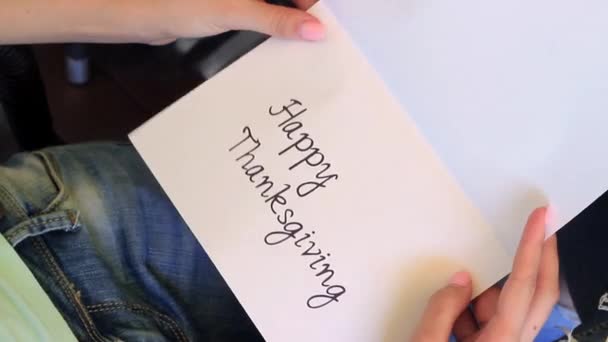 Meisje opent de Card. Happy Thanksgiving is geschreven in de kaart. — Stockvideo