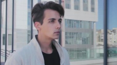 Şık, yakışıklı bir adam sokakta yürürken. Karşısında kendinden emin bir görünüm.