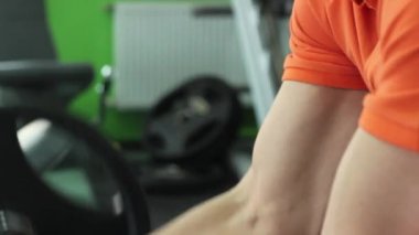 Güçlü ve yakışıklı bir adam spor salonunda eğitiyor.