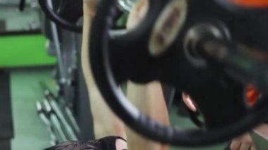 Erkek spor salonunda antrenman ör. Sıra sıkıştırma yapan erkek.