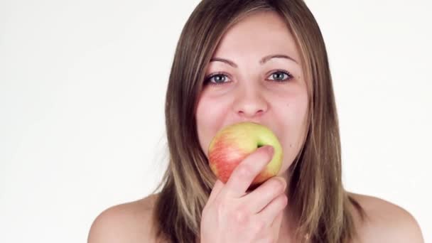 Hermosa chica come una manzana y mirando a la cámara . — Vídeo de stock