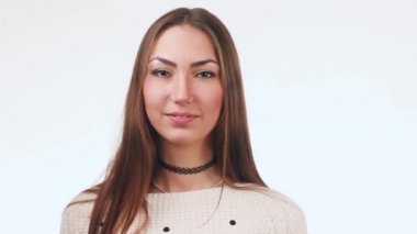 Güzel kız gülümser ve bir hava öpücük gönderir. Stüdyoda beyaz bir arka plan üzerinde duran güzel kadın.