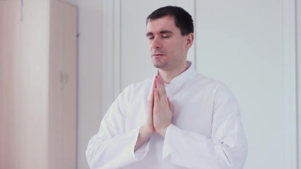 Ardha Padmasana. Йог розмірковує в лотоса. Він сидить на килимок йога. Ardha Padmasana — стокове відео