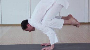 Bir adam yoga uygulamaları. Bakasana