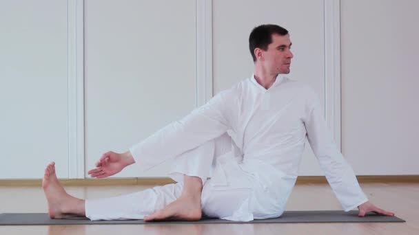 Hombre guapo haciendo yoga. Parivrttasana — Vídeos de Stock