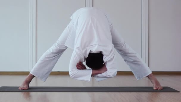 Hombre guapo haciendo yoga. Padottanasana — Vídeos de Stock