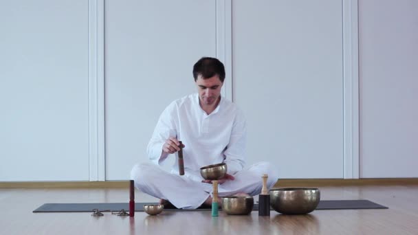 Человек играет на тибетских чашах . — стоковое видео