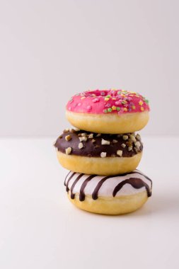 Beyaz arka planda tatlı pembe ve çikolatalı çörekler. Beyaz arkaplanda bir yığın çörekler