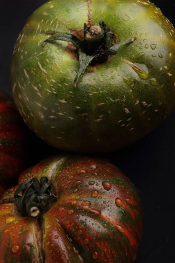 Siyah arka planda organik güzel domatesler. Turuncu renkli güzel domatesler.