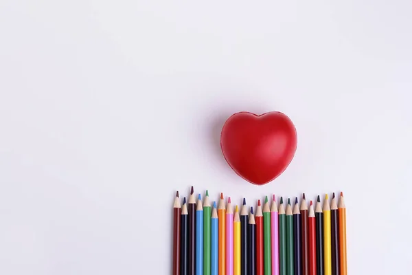 Decorative squishy heart  and  coloor pencils for baby development on white background.