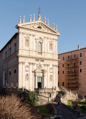 Facade of Classical Baroque style church of Saints Dominic and Sixtus, with sculpted doors and statues, at sunset near Villa Aldobrandini, in Rome, Italy