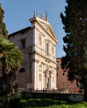 Facade of Classical Baroque style church of Saints Dominic and Sixtus, with sculpted doors and statues, at sunset near Villa Aldobrandini, in Rome, Italy