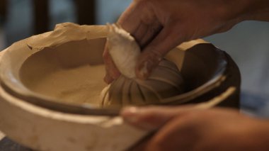 Kil ve kil işleme ile çalışan çömlekçi