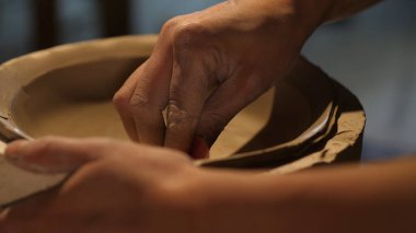 Kil ve kil işleme ile çalışan çömlekçi