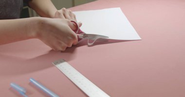 Kız makasla kağıt kesiyor.