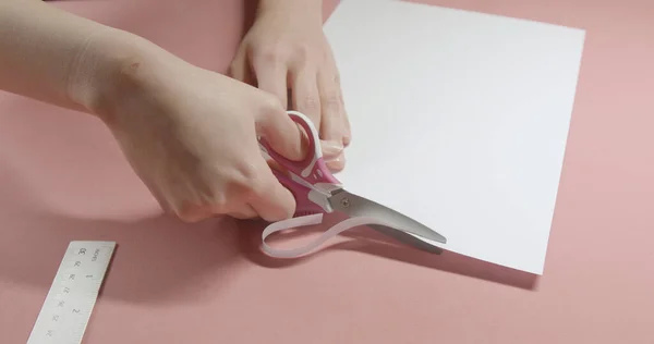girl cuts paper with scissors