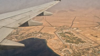 Uçak. Jet. Uçakla. Uçağın penceresinden görüntü. Gün batımında bulutların üzerinde uçan bir uçağın kanadı. Pencereden görülüyor. Seyahat İçeriği. Seyahat fotoğrafçılığı. Tatil.