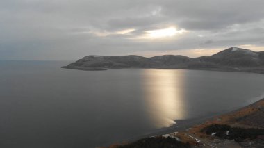 Soğuk Dağ Gölü Karlı Tepeler ile çevrili. Donmuş Alp manzarasının hava görüntüsü. Buzlu Suyu, Karla Kaplanmış Dağları ve Uzak Yaban Hayatı ile Kış Doğası Sahnesi.