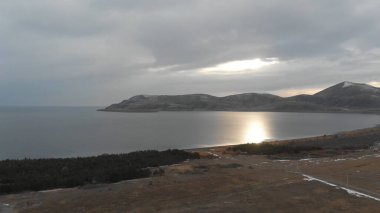 Soğuk Dağ Gölü Karlı Tepeler ile çevrili. Donmuş Alp manzarasının hava görüntüsü. Buzlu Suyu, Karla Kaplanmış Dağları ve Uzak Yaban Hayatı ile Kış Doğası Sahnesi.