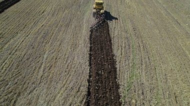 Çiftlik arazisinde traktör, tarlada çalışan sarı tarım makinesi, kırsal tarım ve hasat süreci, modern tarım, ağır makineler ve kırsal arazi konsepti