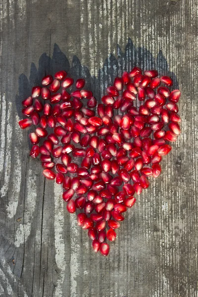 Pomegranate seeds in heart shape — Stock Photo, Image