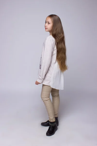 Portrait of teenage girl standing on a gray background — Stock Photo, Image
