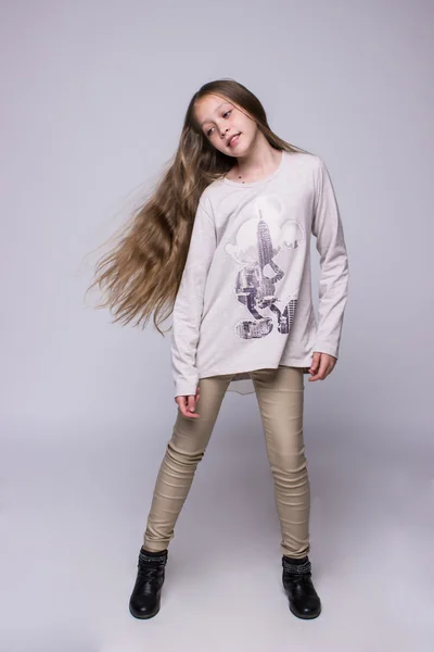 Portrait of teenage girl fashionably dressed standing on a gray background — Stock Photo, Image