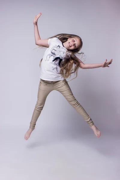 Portrait of teenage girl fashionably dressed standing on a gray background — Stock Photo, Image