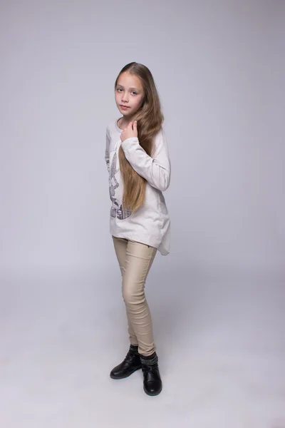 Portrait of teenage girl standing on a gray background — Stock Photo, Image