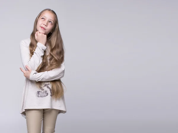 Portrait of bewildered teenage girl standing on a gray background — Stock Photo, Image