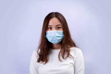 Tıbbi maskeli genç bir kadın koronavirüsten panikliyor. Koronavirüs ve grip paniği kavramı.