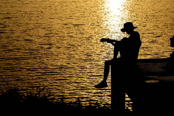 Silueta Kytaristy Hrající Kytaru Řece Pod Západem Slunce — Stock fotografie