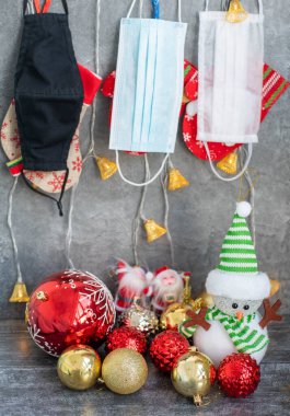 Arka planda koronavirüs olan Noel süslemeleri, Noel çorapları, yüz maskeleri ve oyuncakları olan yatay bir görüntü. Noel için Covid konsepti