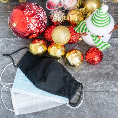 Arka planda koronavirüs olan Noel süslemeleri, Noel çorapları, yüz maskeleri ve oyuncakları olan yatay bir görüntü. Noel için Covid konsepti