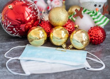 Arka planda koronavirüs olan Noel süslemeleri, Noel çorapları, yüz maskeleri ve oyuncakları olan yatay bir görüntü. Noel için Covid konsepti