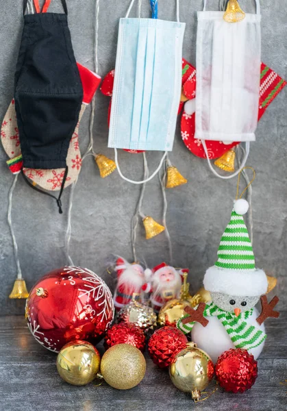 Arka planda koronavirüs olan Noel süslemeleri, Noel çorapları, yüz maskeleri ve oyuncakları olan yatay bir görüntü. Noel için Covid konsepti